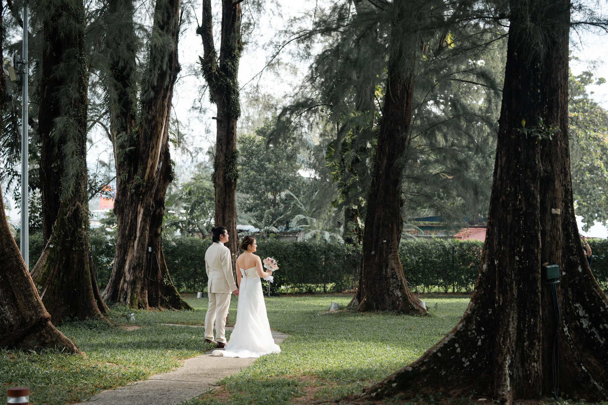 Tender portrait in lush tropical garden by the sea during traditional Chinese wedding reception at Lone Pine Hotel Batu Fe...