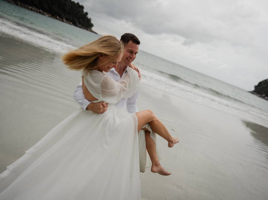 Bride and groom joyful walk through the resort grounds framed by resort architecture and tropical landscape at Pangkor Lau...