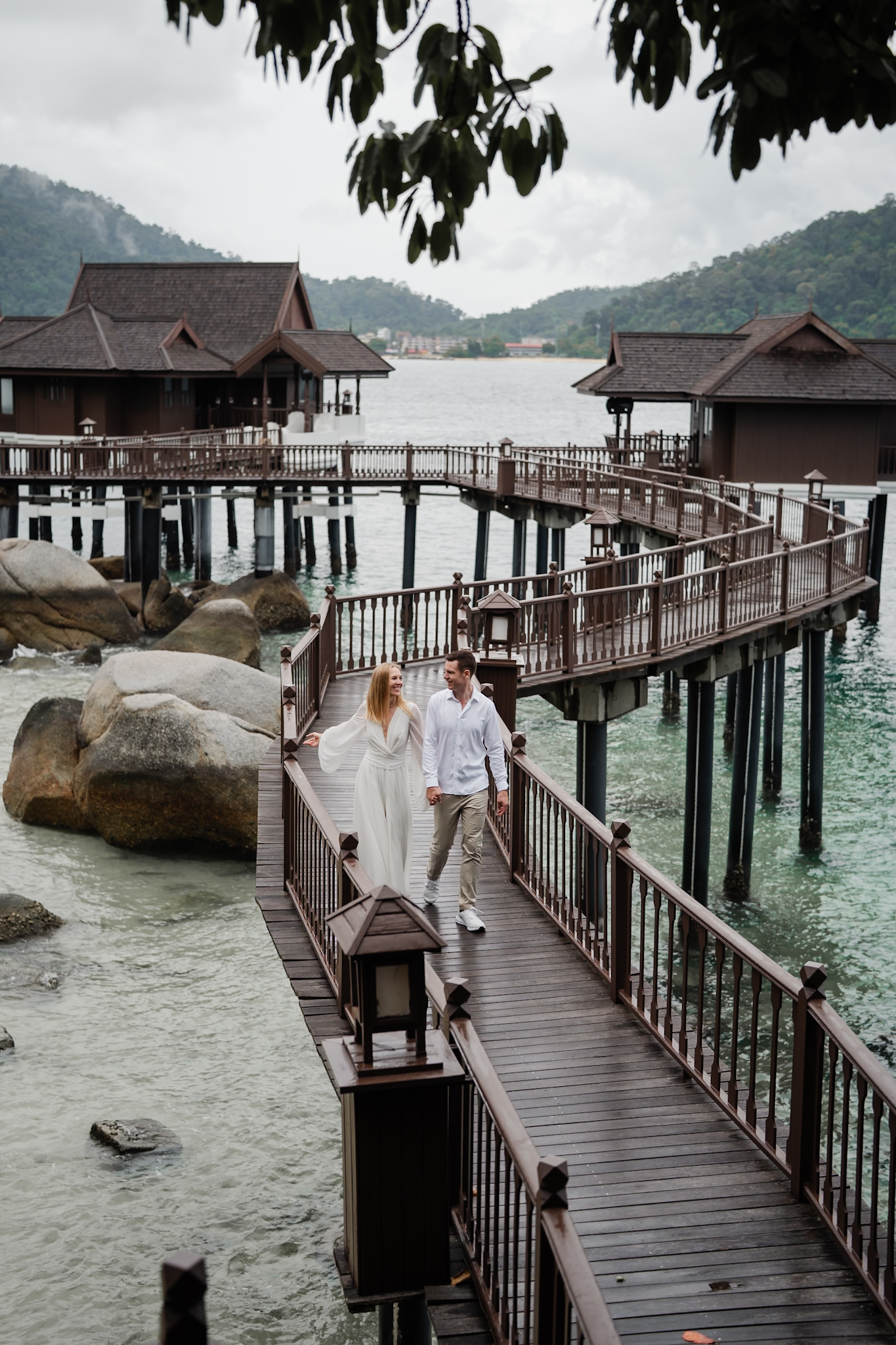 Intimate candid laughter between the couple captured at Pangkor Laut Resort, Perak &mdash; bride and groom hold each other close...
